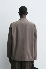 Blazer de corte relajado confeccionada en tejido de algodón con efecto lavado. Presenta cuello con solapas de muesca, cierre frontal de botones, manga larga y bolsillos de plastrón en la parte delantera. Diseño sin forro interior.