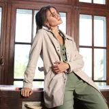 Chaqueta de cuero ovino italiano en color beige, con cuello clásico, cierre frontal de botones metálicos y bolsillos laterales ribeteados. Modelo forrado de largo tres cuartos.