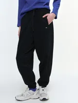 Pantalón tipo jogger de algodón con elastano, color negro, con cintura elástica ajustable mediante cordón, bolsillos laterales y puños elásticos en los tobillos.