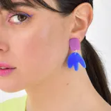 Aros colgantes con forma abstracta, compuestos por un cuadrado fucsia y una pieza inferior azul.