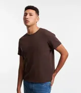 Remera muscle de hombre, color marrón claro, confeccionada en media malla, de cuello redondo y manga corta.