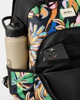 Mochila Rip Curl Ozone 2.0 de 30 litros con diseño estampado de hojas tropicales y bananos sobre base negra. Cuenta con compartimento principal con cierre, bolsillo frontal con cierre, bolsillos laterales de malla y correas ajustables.