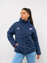 Campera puffer corta de Umbro para el Club Nacional de Football, color azul marino con diseño termosellado. Cuenta con cuello alto, cierre frontal con botones a presión, bolsillos laterales y logo de la marca junto al escudo del club en el pecho.