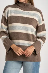 Polera de tejido de punto con diseño a rayas horizontales en tonos marrón, beige y gris. Presenta cuello alto, mangas largas con puños anchos y un corte holgado.