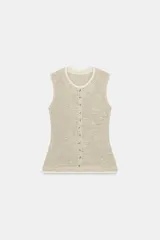 Top tipo chaleco de tejido de punto con algodón, color beige con detalles texturizados. Presenta cuello redondo, sin mangas y cierre frontal con una hilera de botones.
