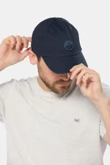 Gorro con visera de lona color verde oliva con parche circular de goma negro en el frente.