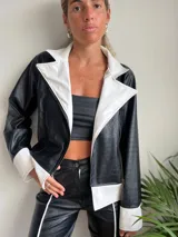 Campera de cuero sintético negra con textura de cocodrilo, con cuello, solapas y puños en color blanco.