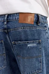 Jean relaxed de pierna amplia, color azul denim, con costuras marcadas y calce holgado.