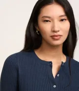 Cardigan corto celeste en punto con textura acanalada, cuello redondo, manga larga y abotonado delantero.