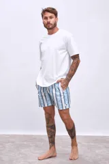 Short de baño celeste con rayas verticales blancas y estampado de flores blancas y azules.