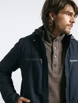 Campera técnica de tejido elástico en color azul marino, con capucha ajustable, cierre frontal y bolsillos laterales con cierre. Cuenta con forro interior de micro polar y ajuste en el ruedo.