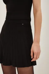 Falda mini tejida de corte acampanado con cintura ancha elástica y acabado brillante con hilos metalizados.