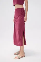 Falda midi de corte tubo confeccionada en modal, con detalle de frunces laterales que aportan movimiento y ajuste al cuerpo.