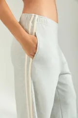 Pantalon de jogging de corte amplio y tiro medio, color gris melange, con cintura elástica y detalle de franjas laterales en tono claro.