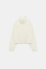 Chaqueta de nylon color crudo, con cuello alto, mangas largas, bolsillos delanteros, bajo abullonado con elástico y cierre frontal con botones forrados.