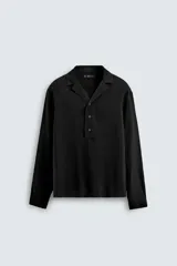 Camisa de corte relajado confeccionada en tejido mezcla de viscosa, con cuello solapa, cierre frontal de tres botones y manga larga con puños abotonados.