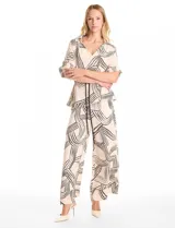 Conjunto de dos piezas compuesto por camisa de cuello solapa con escote en V y pantalón estilo palazzo de tiro alto. Ambas prendas presentan un estampado lineal abstracto en color negro sobre fondo beige. La camisa cuenta con mangas cortas ajustables mediante trabillas y un cordón trenzado negro para entallar la cintura. El pantalón posee cintura elastizada y bolsillos laterales.