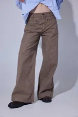 Pantalón de jean color marrón con corte recto y tiro medio-alto. Presenta un diseño de cinco bolsillos con costuras reforzadas y cierre frontal con botón y cremallera.
