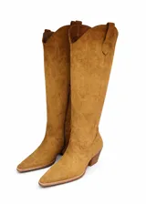 Botas texanas de caña alta confeccionadas en gamuza color camel, con diseño de costuras decorativas en la caña, punta fina y taco cuadrado de madera.