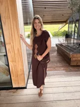 Vestido midi marrón oscuro de corte recto y mangas cortas, con cuello redondo adornado con costuras decorativas y rombos de cuero camel bordados en el frente. Cuenta con aberturas laterales con detalles de costura a contratono.