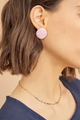 Aros tipo botón color lila con lunares dorados.