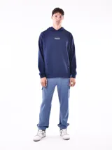 Hoodie negro con capucha y bolsillo canguro. Presenta un pequeño texto estampado en blanco en el pecho que dice: "STREET STYLE HAS REVOLUTIONIZED THE FASHION INDUSTRY".