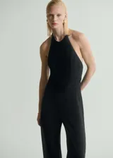 Mono largo de fiesta negro con espalda descubierta, cuello halter y cierre de cremallera en la parte posterior. Diseño recto y sin mangas.