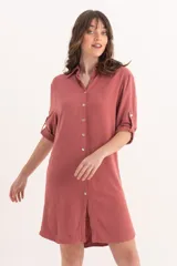 Camisa larga color rosa de lino con cuello clásico, abotonada al frente y mangas 3/4 con trabillas.