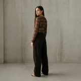 Pantalón de pana marrón oscuro, de corte recto y tiro alto, con bolsillos traseros.