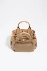 Bolso bandolera Pocket Bimba Y Lola de tamaño mediano, color tostado, confeccionado en nylon con estructura blanda, doble asa de mano y correa de tejido. Incluye un bolsillo exterior frontal con cierre y el logo metálico de la marca.