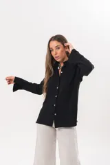 Camisa de manga larga color negro, de cuello redondo con frunces, abotonada en el frente y puños abiertos con tajo.