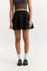 Falda corta blanca con volados en capas, confeccionada en tejido de algodón con bordado estilo broderie. Cuenta con cintura elástica.