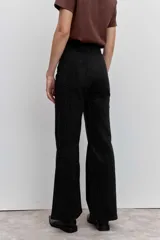 Pantalón de jean corte wide leg color negro, con sutiles detalles de brillo en toda la superficie. Presenta tiro alto, cierre frontal con botón y bolsillos laterales.