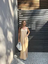 Vestido largo color beige, de viscosa, con tirantes finos, escote en V y aberturas laterales en la falda.
