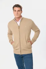 Campera tejida de algodón color beige, con cierre frontal, cuello alto y bolsillos laterales.