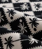 Enterito corto de viscosa con estampado de cuadros y cocoteros, escote en U y breteles ajustables. Tiene lazos laterales en la cintura.