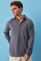 Buzo de friza de algodón color gris oscuro, con cuello polo y cierre frontal de botones, de manga larga y calce relajado.