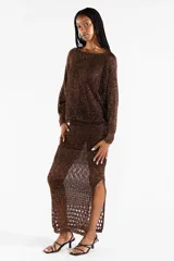 Falda midi tejida con diseño calado y abertura frontal, color marrón con hilos metalizados dorados.