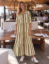 Vestido camisero largo de corte amplio, con diseño de rayas verticales en tonos crudo, chocolate y verde lima. Cuenta con cuello camisero, cierre frontal con botonadura completa y mangas largas.
