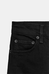 Jeans capri negro de tiro medio, corte recto y diseño de cinco bolsillos. Cuenta con trabillas en la cintura y cierre frontal con cremallera y botón metálico.