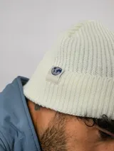 Gorro tipo beanie de punto acanalado en color negro, con vuelta y etiqueta de la marca Umbro cosida en el lateral.