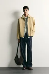 Cazadora regular fit de cuero con acabado de ante en color beige, con cuello solapa, bolsillos de plastrón en la cadera y cierre frontal de cremallera oculta por solapa con botones a presión.