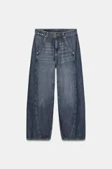 Jeans de tiro alto con corte balloon y pernera holgada. Presenta diseño de cinco bolsillos, cierre frontal con cremallera y botón, y detalle de costuras marcadas en el delantero y la espalda.