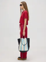 Pantalón de tiro alto, corte holgado y pierna ancha, confeccionado en algodón color beige. Presenta una franja lateral en contraste y cintura elástica con cordón ajustable.