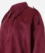 Campera bomber de gamuza sintética color bordó, con cuello clásico, cierre frontal, hombros caídos y puños ajustados.
