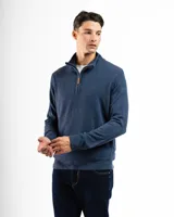 Buzo de tejido de punto azul melange, con cuello alto y cierre frontal parcial con tirador de cuero. Presenta puños y ruedo acanalados.