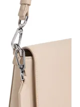 Cartera de hombro rectangular color beige claro, con solapa frontal y logo metálico de Calvin Klein. Incluye dos correas desmontables: una fina ajustable de cuero sintético y una ancha de tela tejida con el nombre de la marca repetido.
