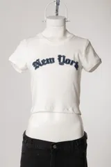 Remera de morley de manga corta, color gris, ajustada al cuerpo y elastizada, con bordado estilo college con la inscripción 'New York' en el pecho.