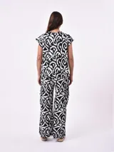 Remera blanca de manga corta con cuello redondo y un estampado abstracto en blanco y negro.