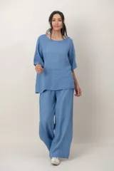 Blusa de lino color marrón oscuro, con escote redondo, mangas cortas amplias y detalle de alforzas verticales en el lateral derecho.